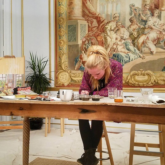 Photo of Rhiannon making art at a table at the Chateau Orquevaux